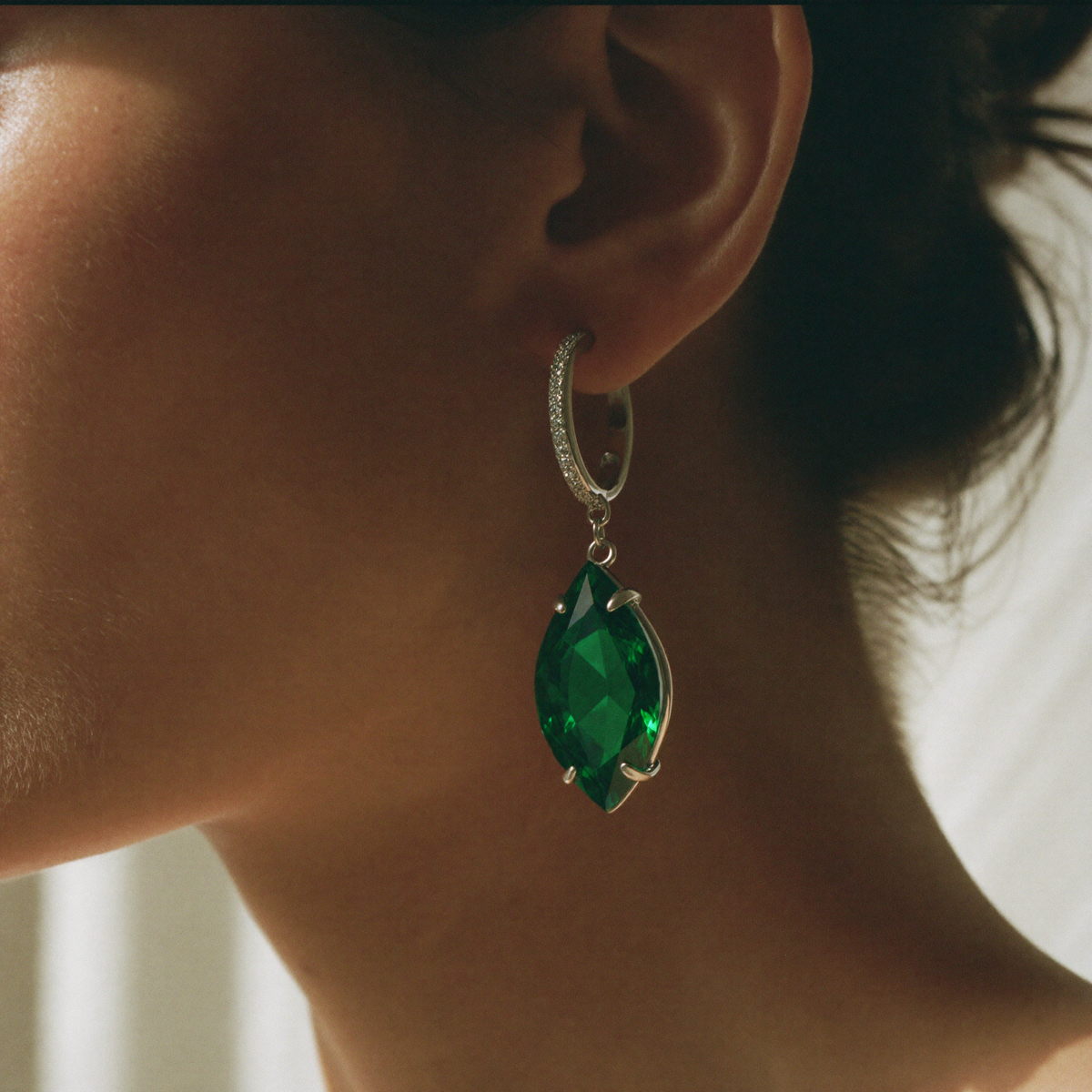 Model wearing the emerald pear drop earring, close-up editorial