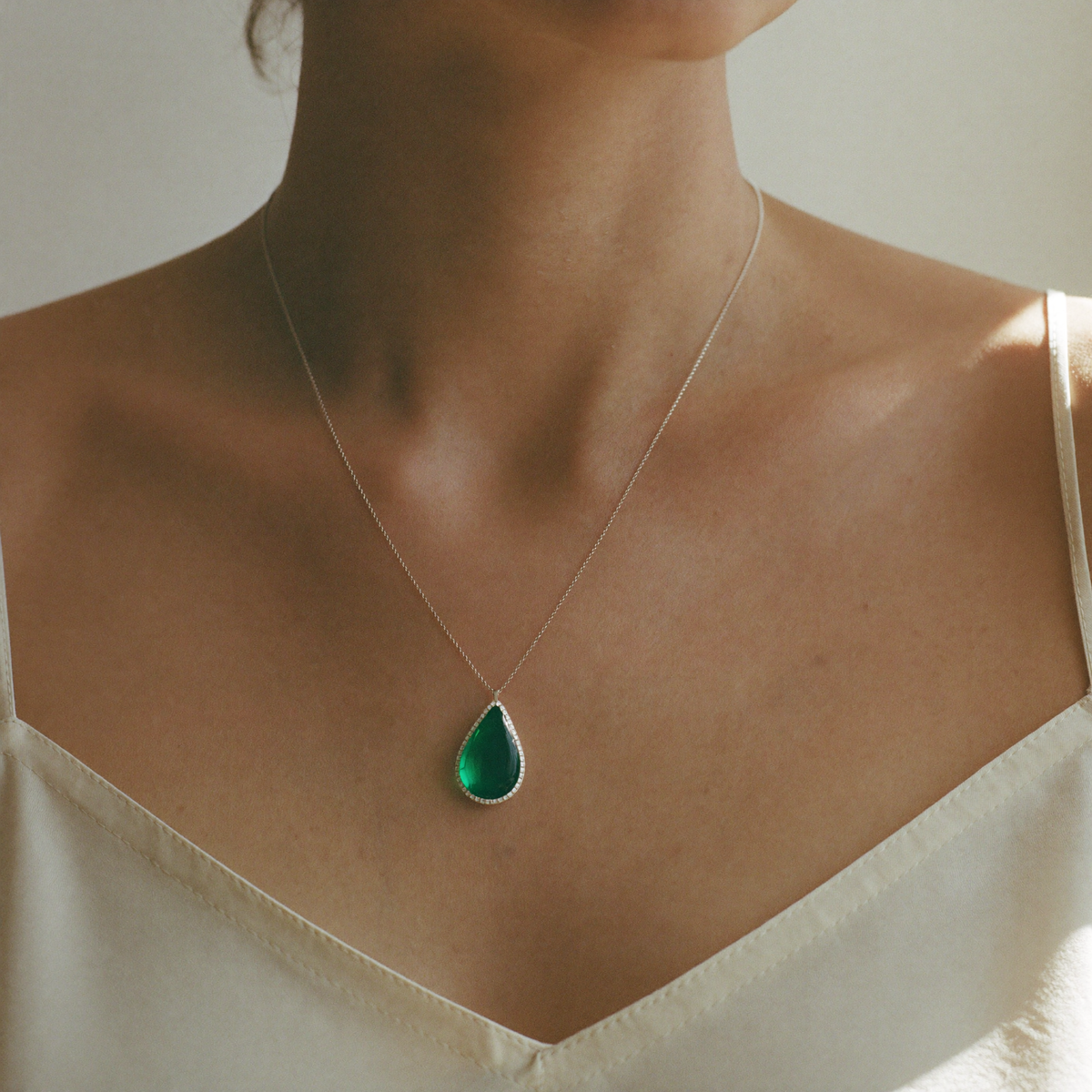Model wearing the emerald teardrop pendant necklace at the neckline